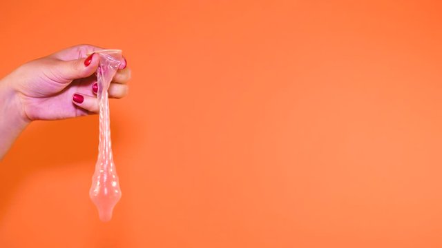 Woman holding condom prevent pregnancy, is her hand holding an open condom, the concept of safe sex. Protection against AIDS and birth control, color background