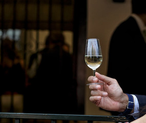 Hand holding glass of fino sherry (manzanilla sherry) at the April Fair (Feria de Abril), Seville Fair (Feria de Sevilla), Andalusia, Spain. Travel and tourism concepts. Selective focus