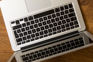 opened gray laptop close-up viewed from an oblique position on top of a wooden table