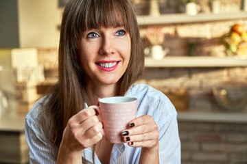 Happy woman at home drinking coffee at morning