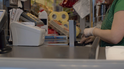 Hands of cashier putting cash in cash box