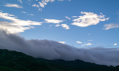 Obraz premium a mountain landscape surrounded by rain cloud.