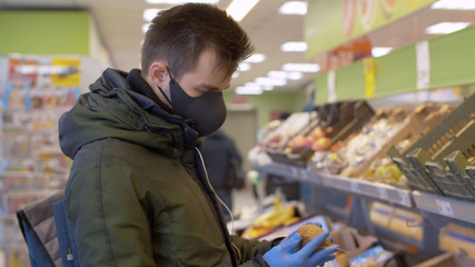 A man choosing kiwi in the supermarket
