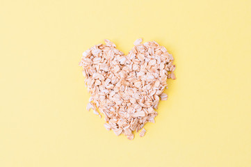 Oat flakes on a yellow background. Healthy eating concept.