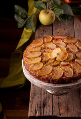 French sweet pie tart tatin apple cake upside down and fresh apples  over on old rustic wooden...
