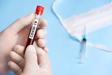 Naklejka premium Doctor holding test tube with blood for 2019-nCoV analyzing. Coronavirus disease COVID-19 pandemic