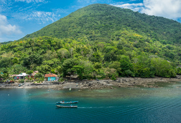 Local boatmen passing through each other near gunung Api volcano in Banda , Maluku, Indonesia banda sea eastern remote destination. Seen from KM Nggapulu ferry traveling from Jakarta to Kei islands