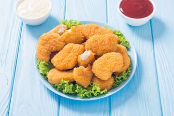 Chicken nuggets in plate on rustic background