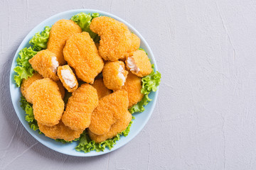 Chicken nuggets in plate on rustic background