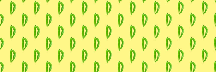 Seamless pattern of green hot chilli peppers on a yellow. Food background, texture. Minimal concept