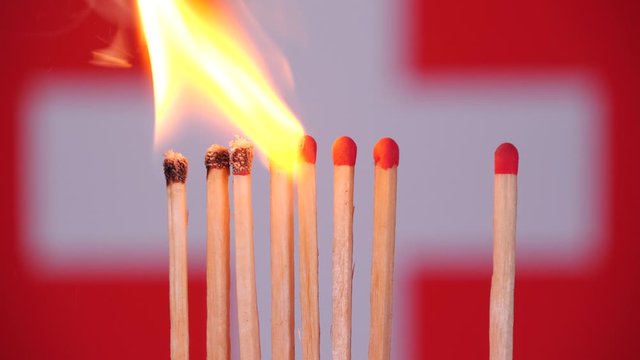 Coronavirus outbreak, social distancing in Switzerland. Concept: spreading epidemic, domino effect, COVID-19,  isolated burning matches, stop spreading virus