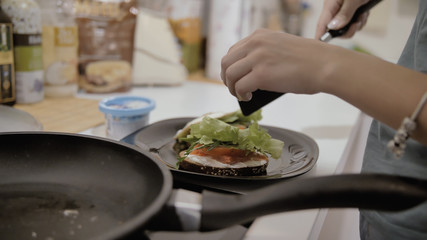 Girl makes tasty beautiful healthy sandwich with egg and lettuce