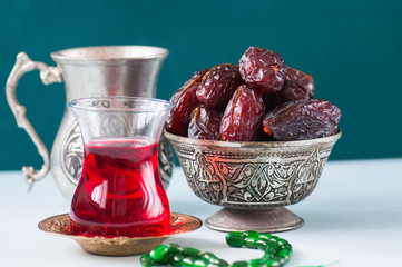 Medjoul kurma in a vintage bowl and glass of turkish tea.