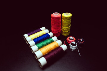Sewing multi-colored threads on a black background