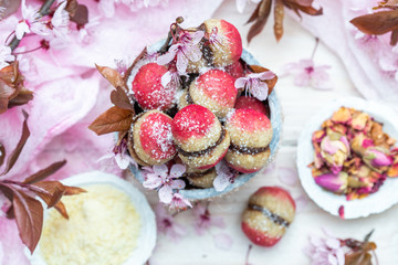 Raw vegan peaches cookies with pink spring flowers on a white table. Peach cookie for vegans. Raw food sweets.