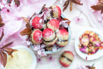 Fototapeta na wymiar Raw vegan peaches cookies with pink spring flowers on a white table. Peach cookie for vegans. Raw food sweets.