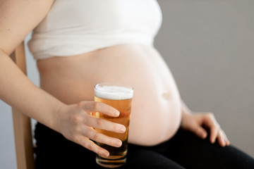 pregnant woman with a glass of beer in her right hand