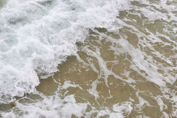 Beach texture. Golden sand and sea foam pattern. Beach background with copy space. Abstract sea...