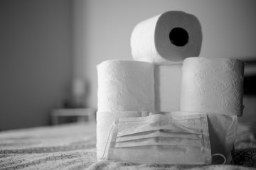 Background with toilet paper, and a mask. Coronavirus, panic. Buying toilet paper.