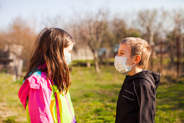 Fototapeta premium Brother and sister in protective masks outdoors
