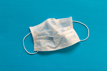 CORONAVIRUS. A crumpled medical mask on a blue background. Concept of protection against coronavirus.