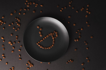A cup of coffee. The cup on a matte black plate on a black background. Coffee beans around the plate. Black composition. Dark mode style. Coffee time