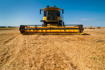 closeup view of big yellow modern combine harvester. harvesting cereals at field