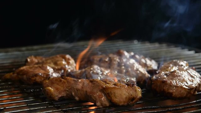 Grilled meat/steak on a grill with smoke .