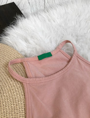 Green blank tag on a pink t-shirt close-up on a background of white fur