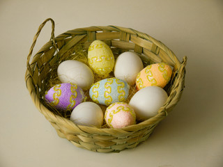 Easter eggs in a large basket on a light background. The concept of celebrating the Christian holiday of Easter.