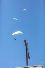 Skydivers with a colorful canopies of a parachutes on the background a blue sky