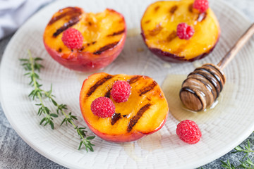 Naklejka na ściany i meble Summer dessert: Cooking Ripe grilled peaches with honey
