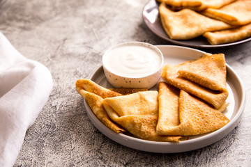 Traditional Russian pancakes. Fried crepes with sour cream