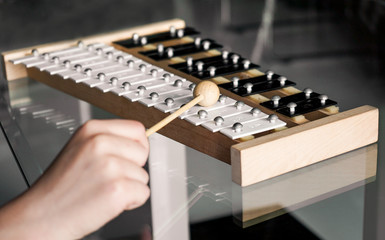 Xylophone closeup with a hammer in a child's hand