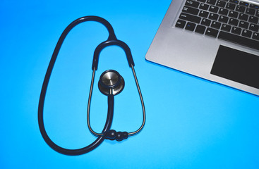 Doctor's stethoscope and laptop placed on a blue background