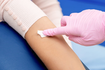 Nurse disinfecting arm skin.