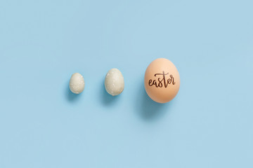 Egg with inscription EASTER over light blue background