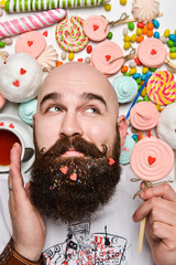 Moscow, Russia, April 2015 - Happy bearded man biting cream cake isolated on white background