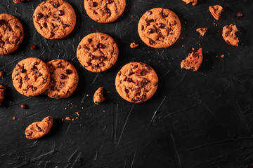 Chocolate chip cookies on a dark background, shot from above with copy space