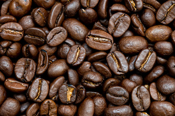 Dark coffee beans background texture of roasted seeds close up