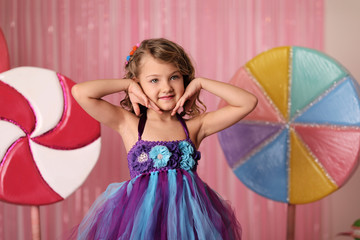 portrait of a girl-model, having fun at a birthday party in a beautiful, delicious, pink candy...