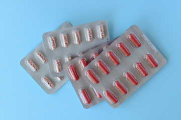 Assorted pharmaceutical medicine capsules over blue background
