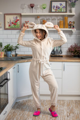 cute young brunette woman in fluffy pajamas on a white scandinavian kitchen