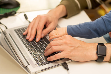 Coronavirus concept. Close op of hands of a man working from home with the baby on his laps.