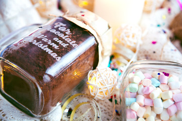 christmas cacao and marshmallow glass jar on textile