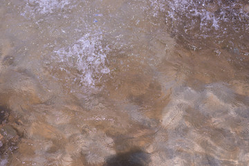 Water surface with waves. Water background, drops and splashes from the fountain on the water