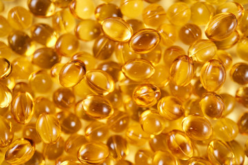 Closeup of a pile of vitamin D yellow pills (top view)
