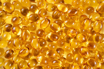Closeup of a pile of vitamin D yellow pills (top view)