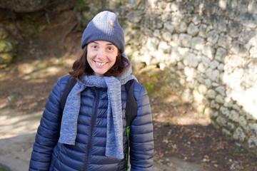 Laughing brunette woman with a lovely smile in winter tourism with woolen hat scarf