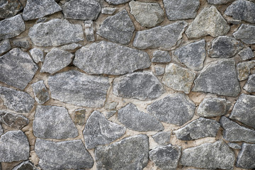 Cracked real stone wall surface with cement